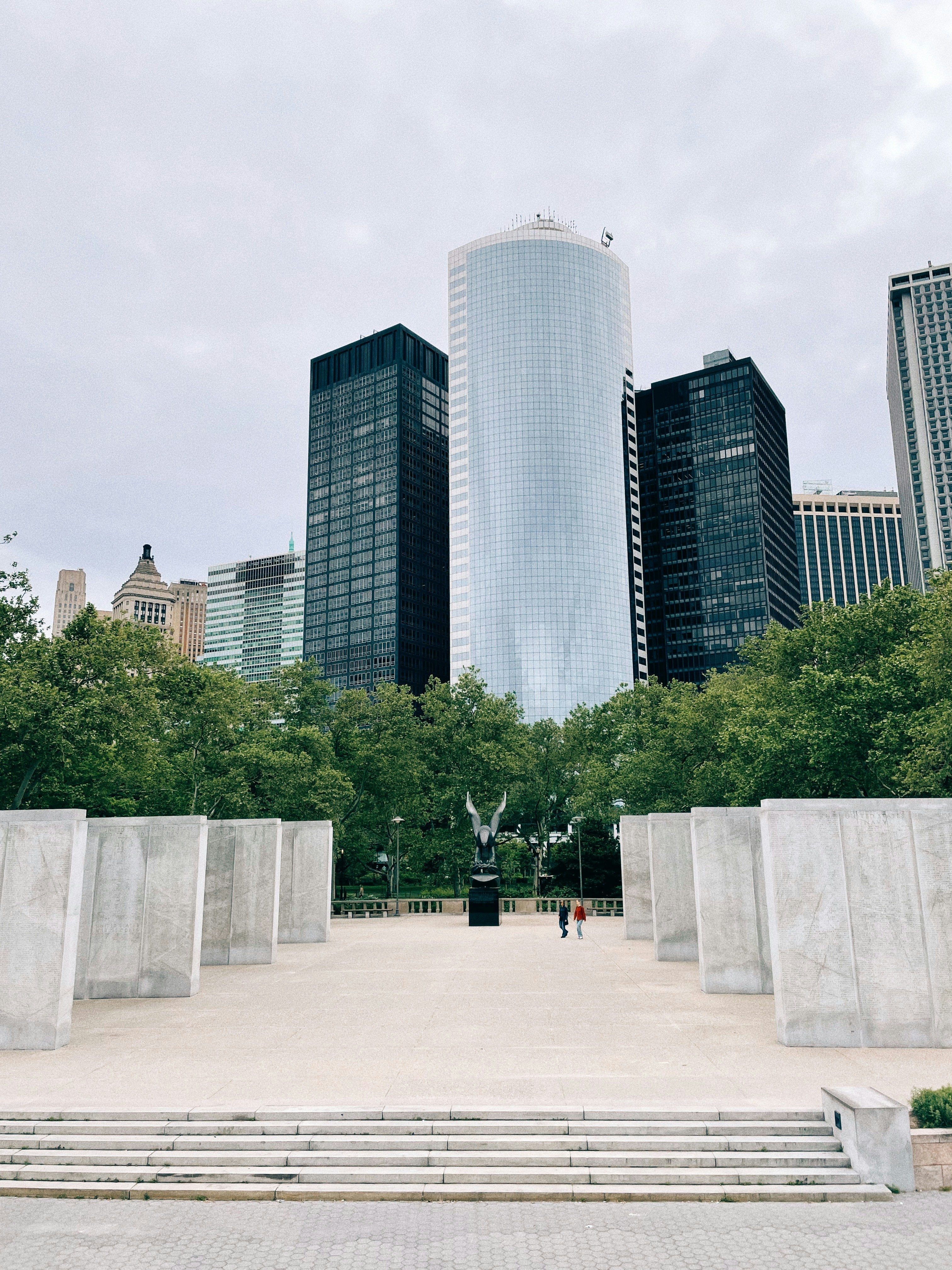 高層ビルの隣の公園に座っているベンチのカップル