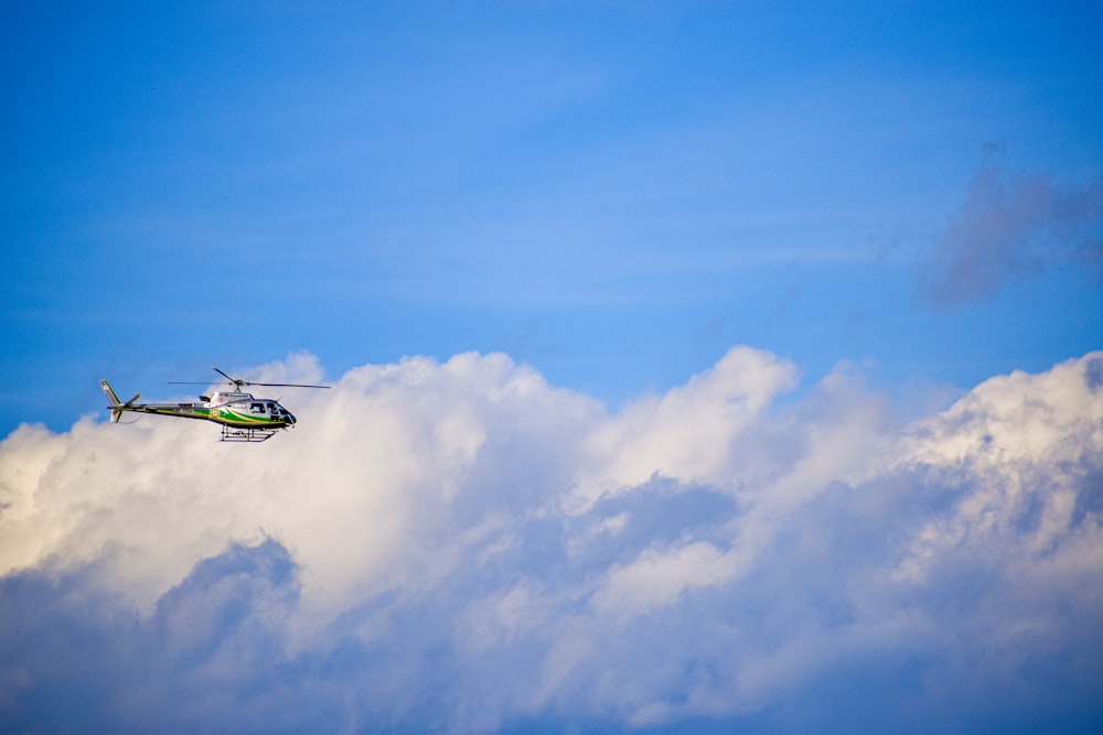 a helicopter flying through a cloudy blue sky