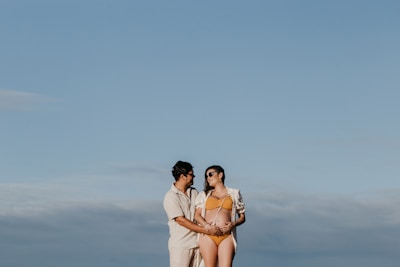 a man and a woman standing next to each other on a beach