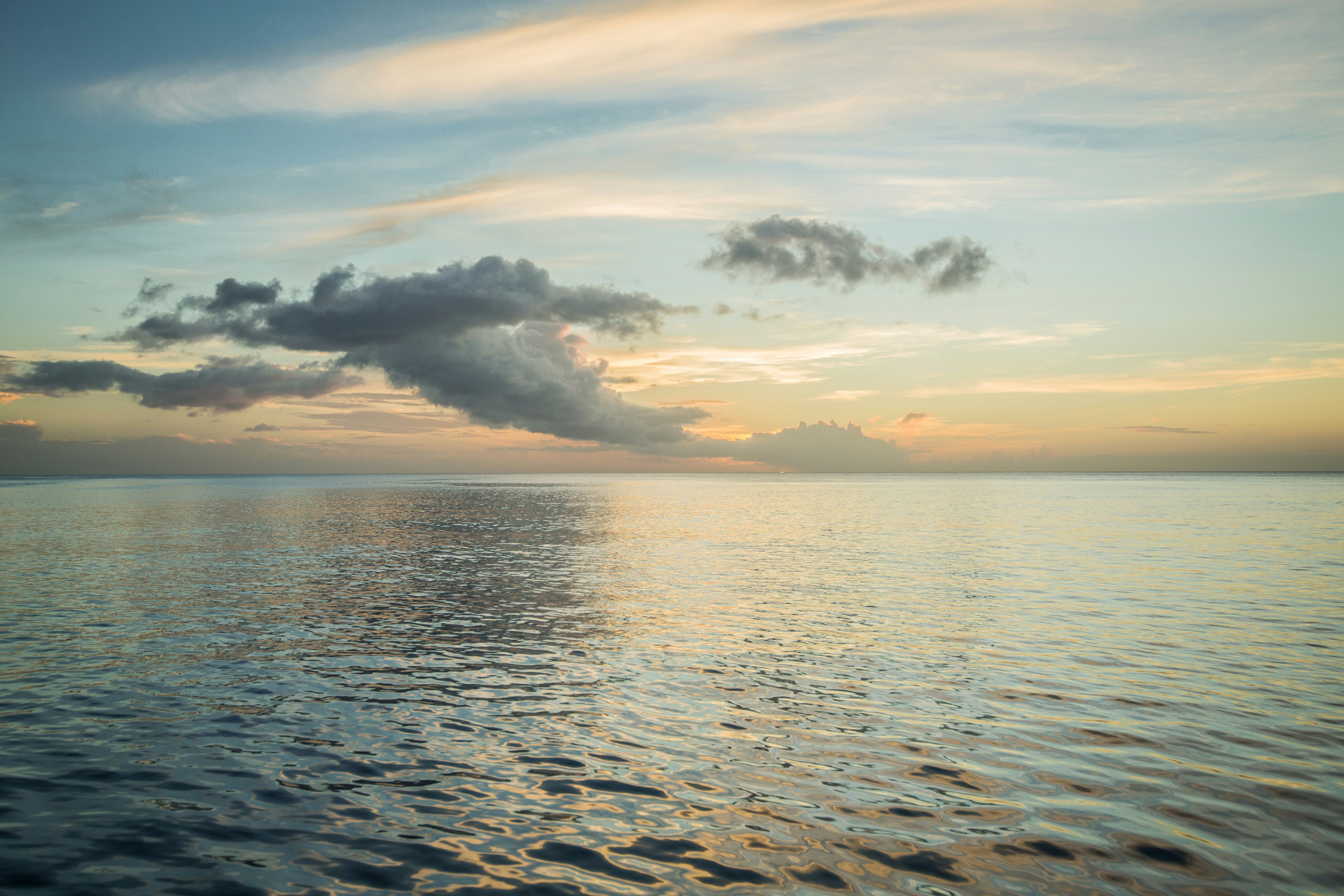 a large body of water under a cloudy sky, Somewhere in the Caribbean.