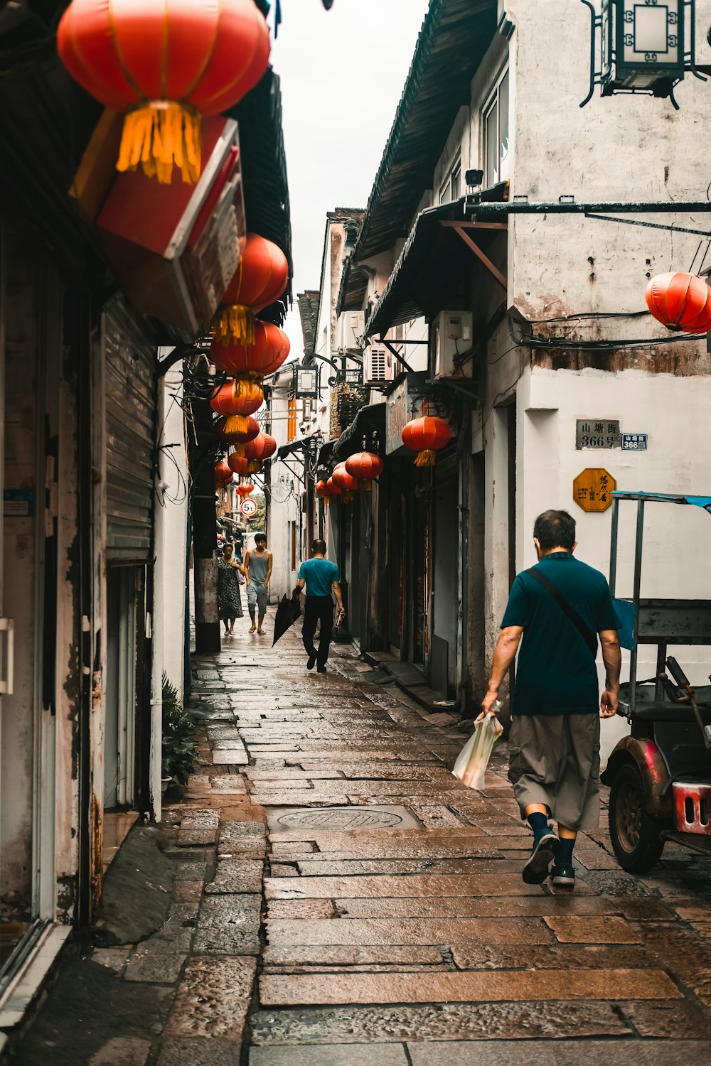 a man is walking down a narrow street