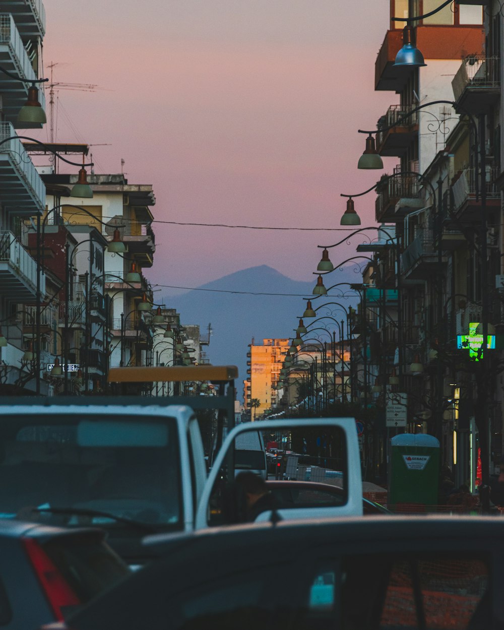 a city street filled with lots of traffic next to tall buildings