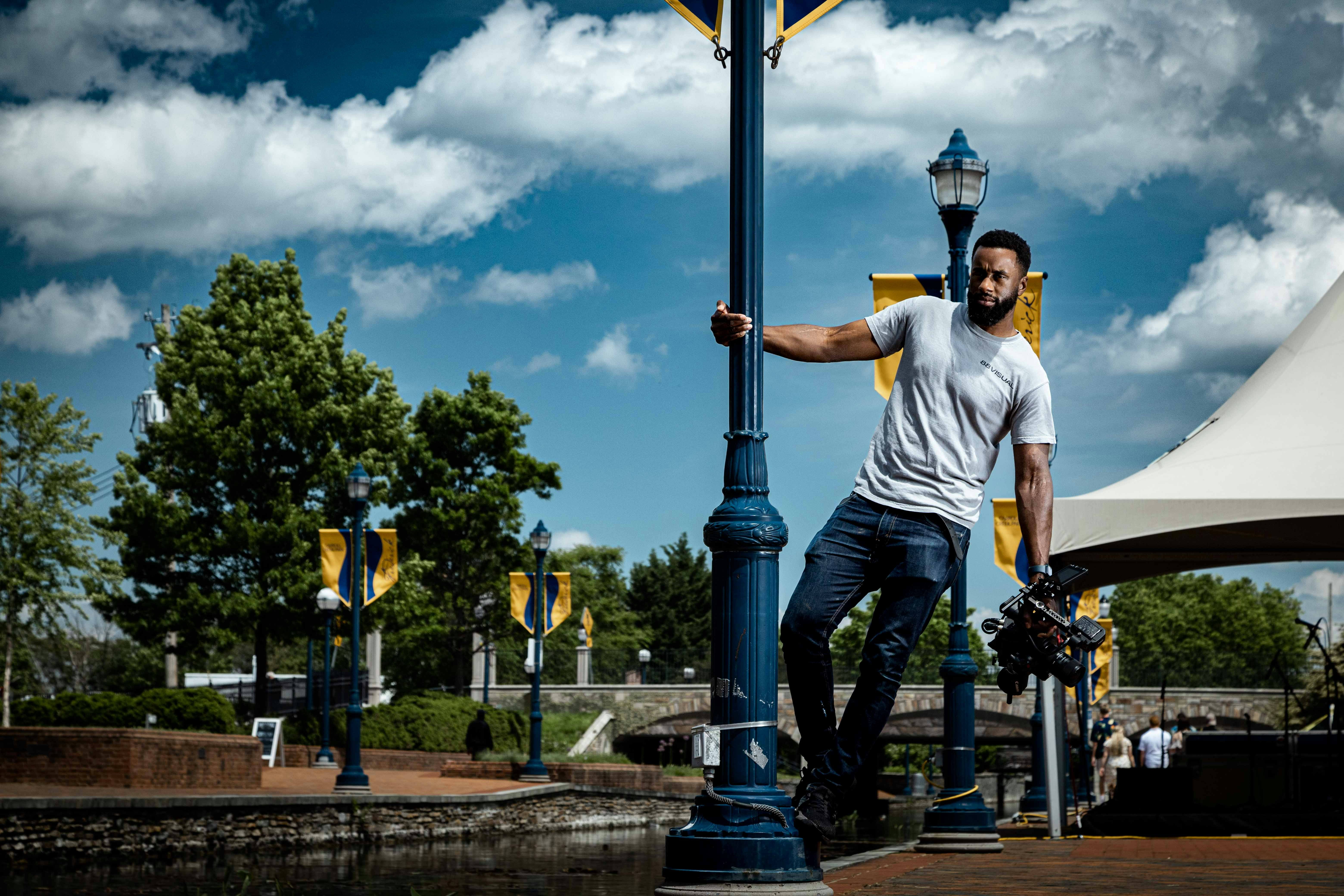 A man leaning on a street light pole photo – Free Blue Image on Unsplash