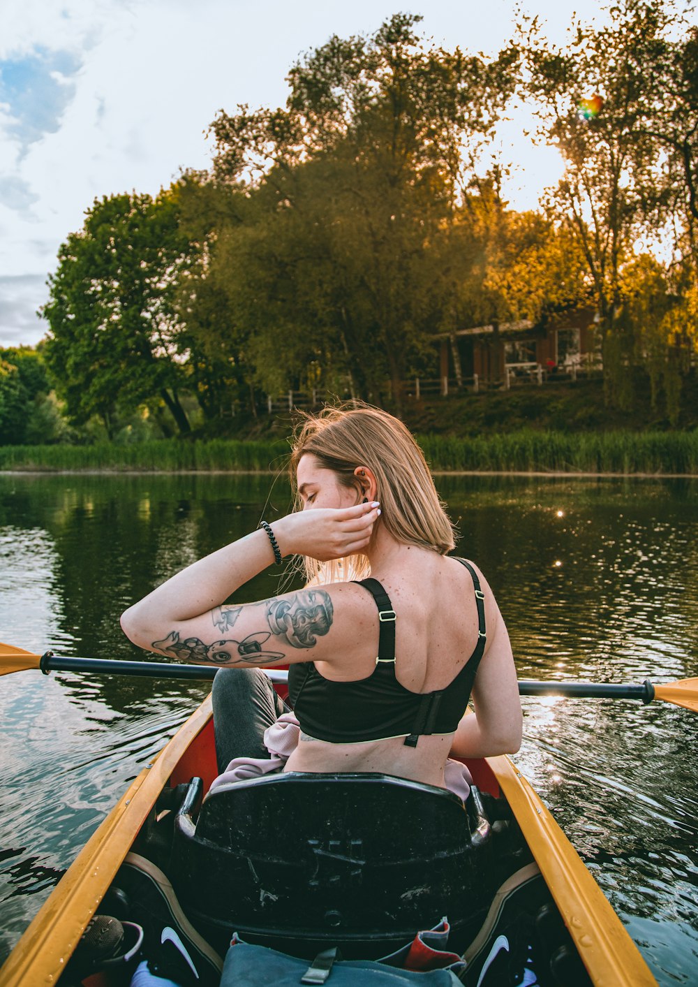 a woman in a bikini paddling a canoe on a lake