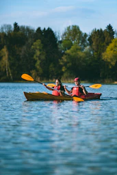 two people in a kayak paddling on a lake