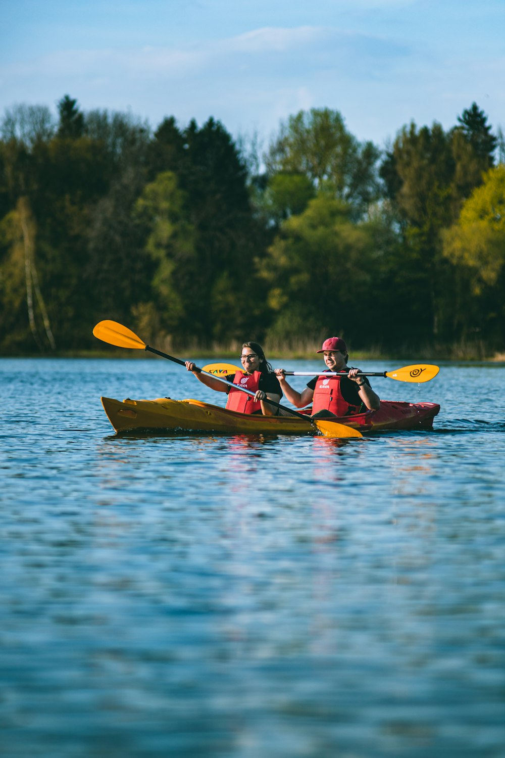 two people in a kayak paddling on a lake