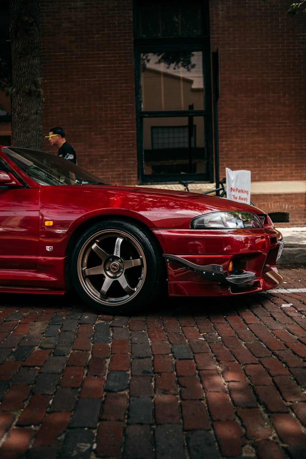 a red sports car parked in front of a brick building