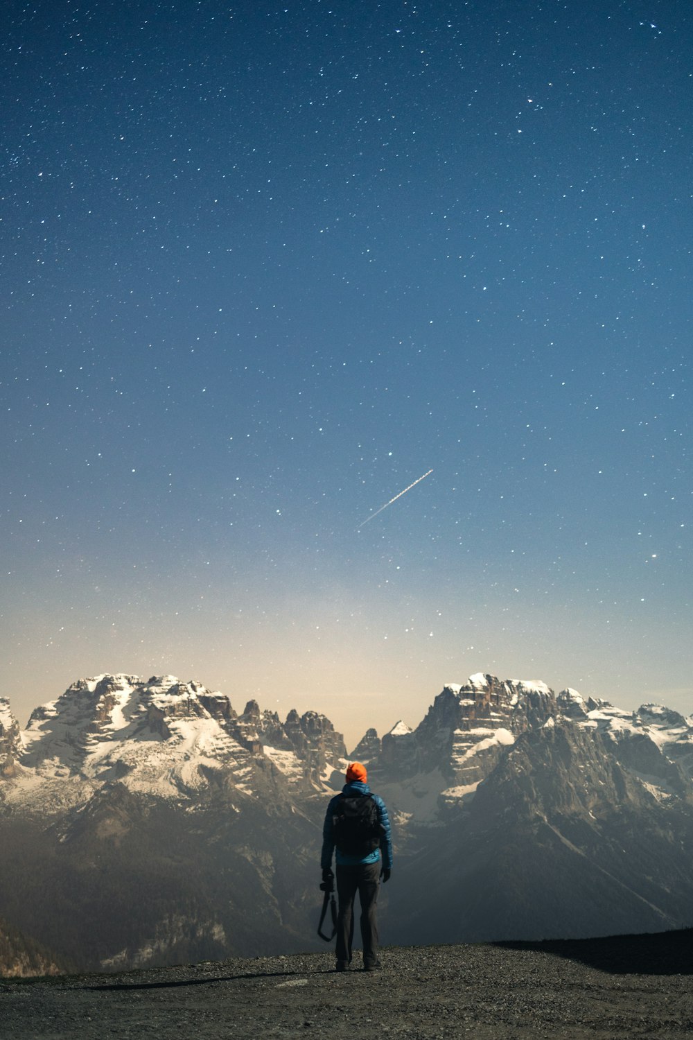 a man standing on top of a mountain under a sky filled with stars