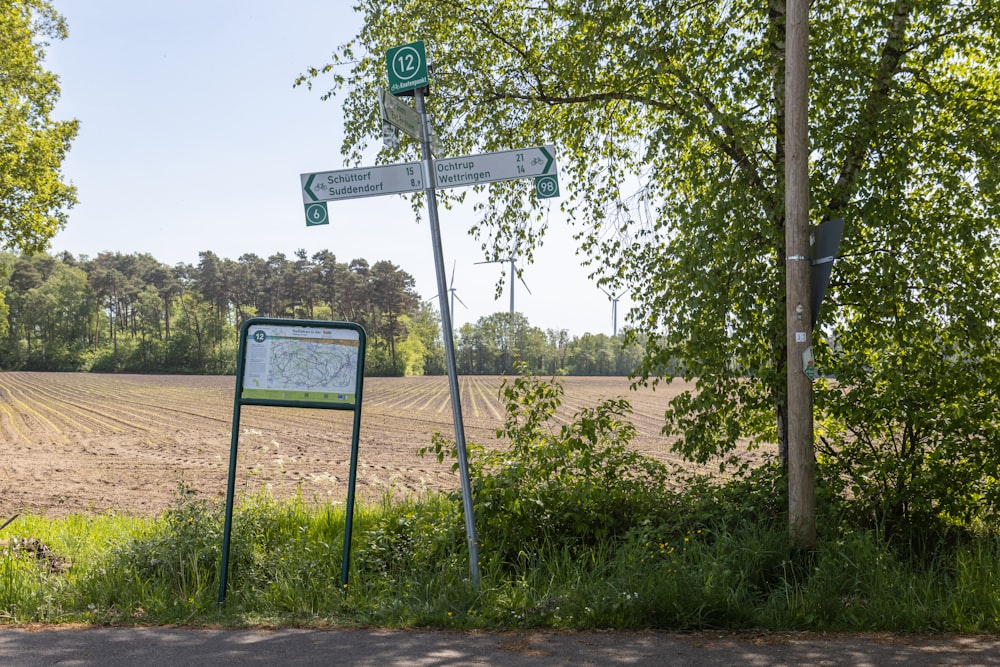 a street sign sitting next to a lush green field