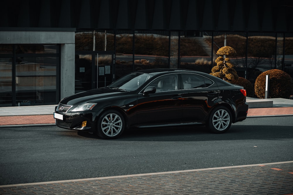 a black car parked in front of a teddy bear