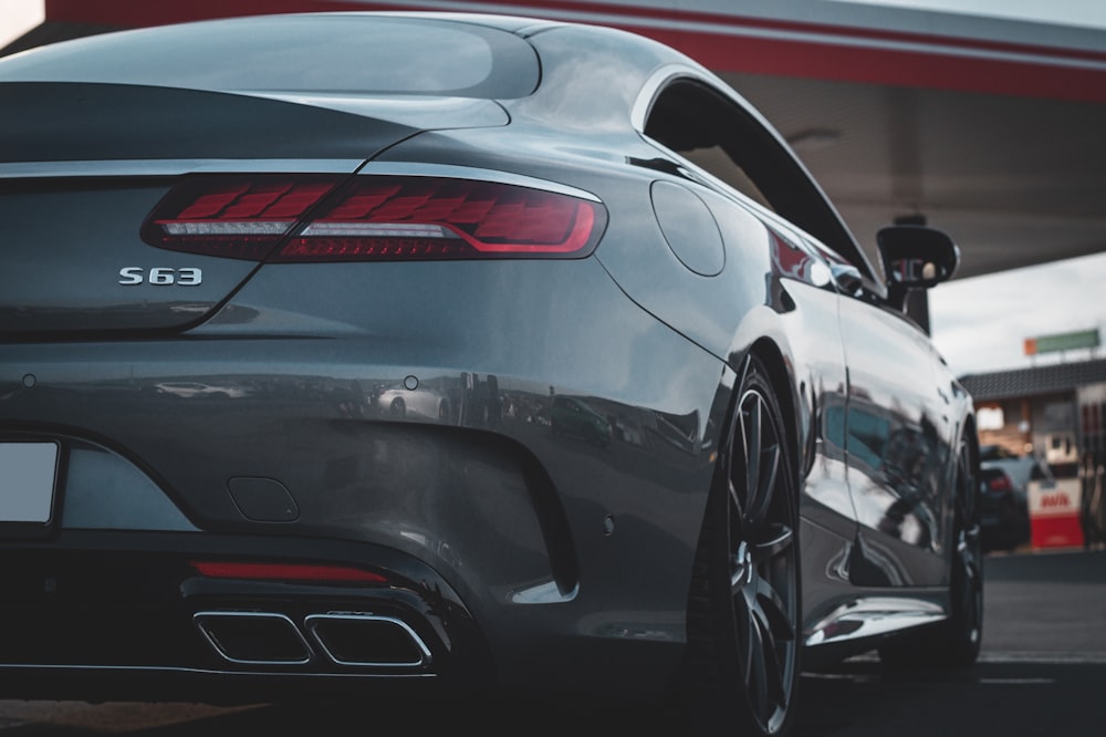 a grey car parked in front of a gas station