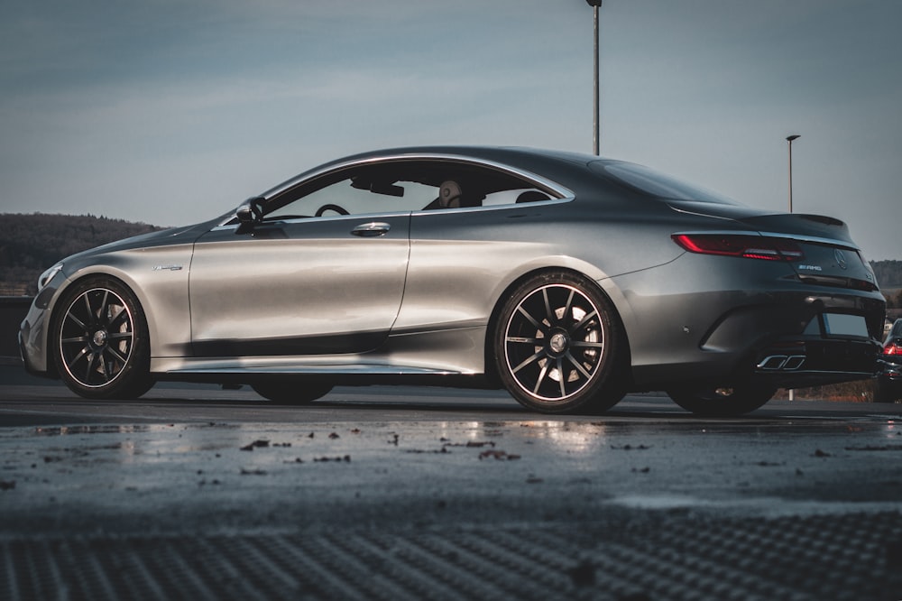 a silver car parked on a wet parking lot