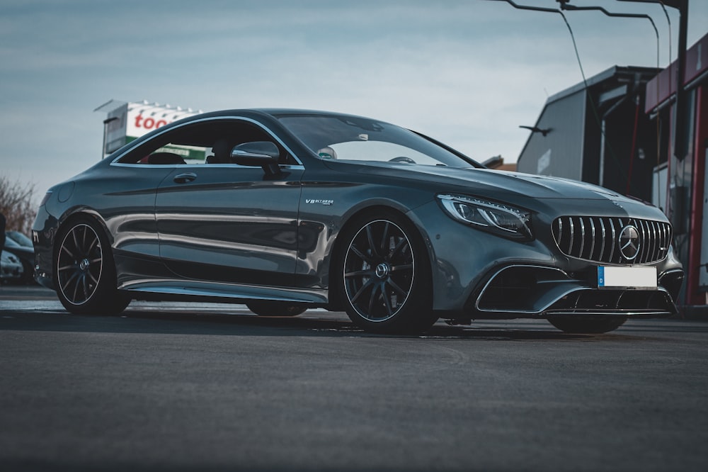 a grey car parked in front of a building