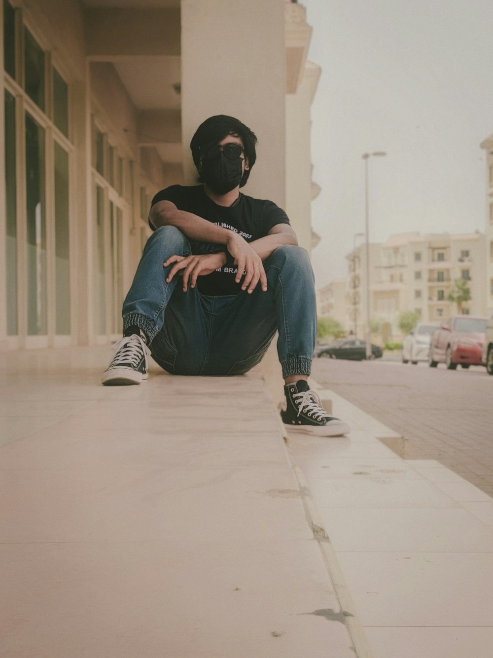 a man sitting on the side of a building