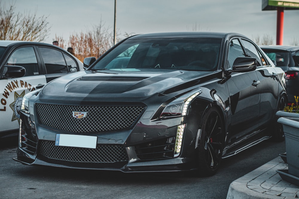 a black cadillac parked in a parking lot