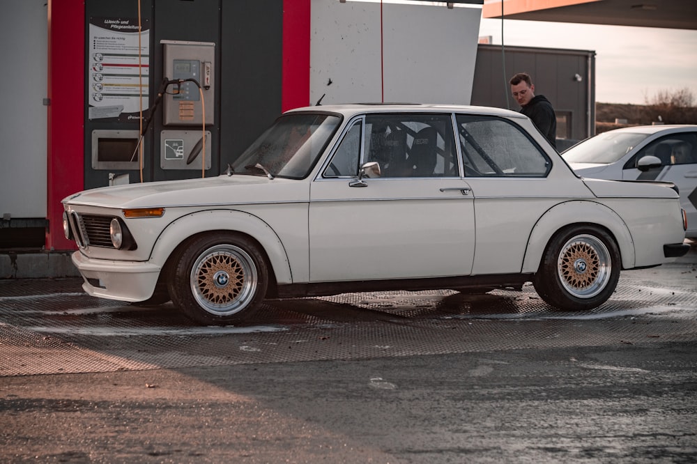 a white car parked in front of a gas station