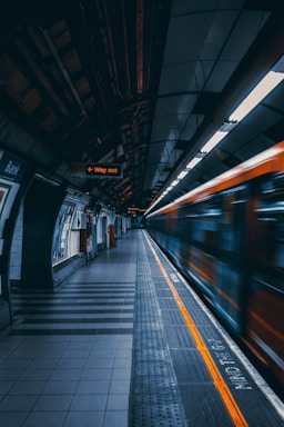 a train traveling through a train station next to a platform