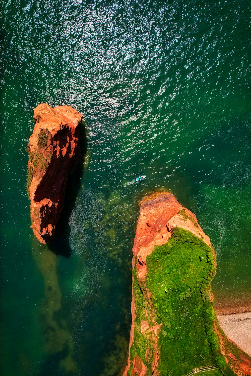 two large rocks sticking out of a body of water
