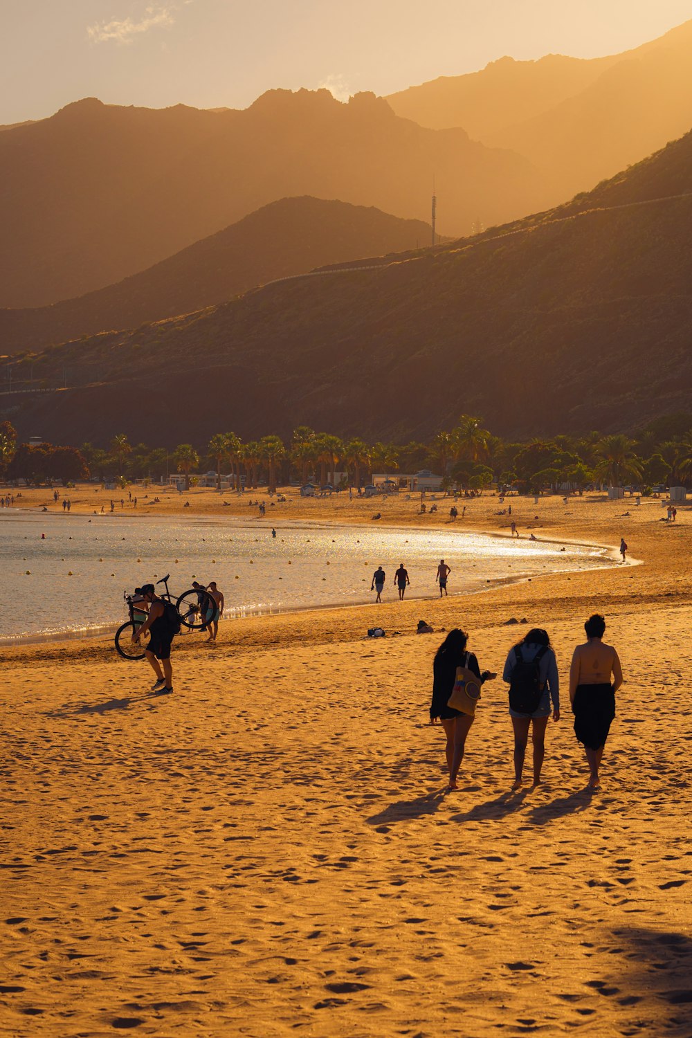 a group of people walking across a sandy beach