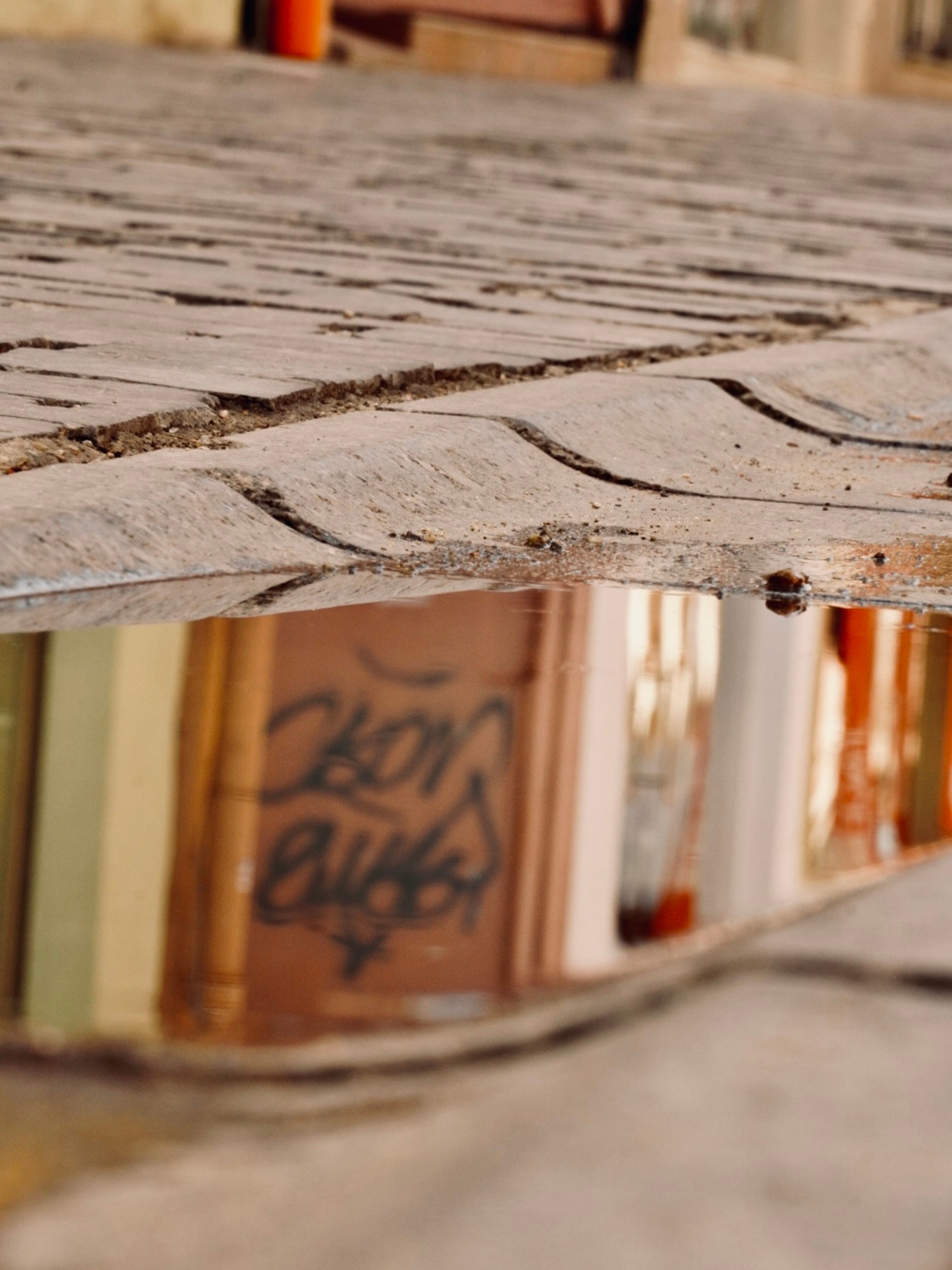 a reflection of a building in a puddle of water