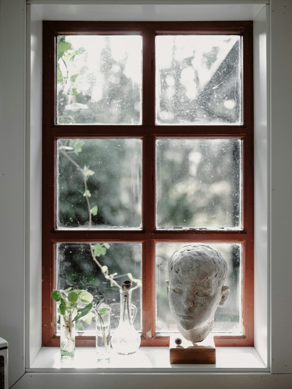 a window sill with a statue of a head on it