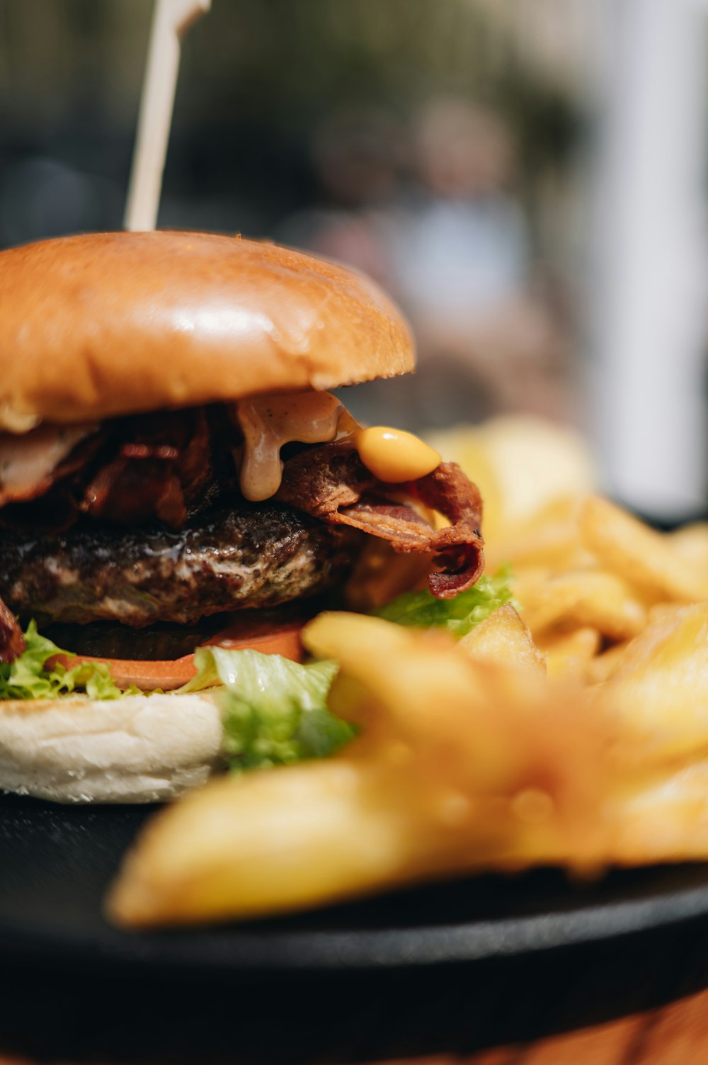 a hamburger and french fries on a black plate