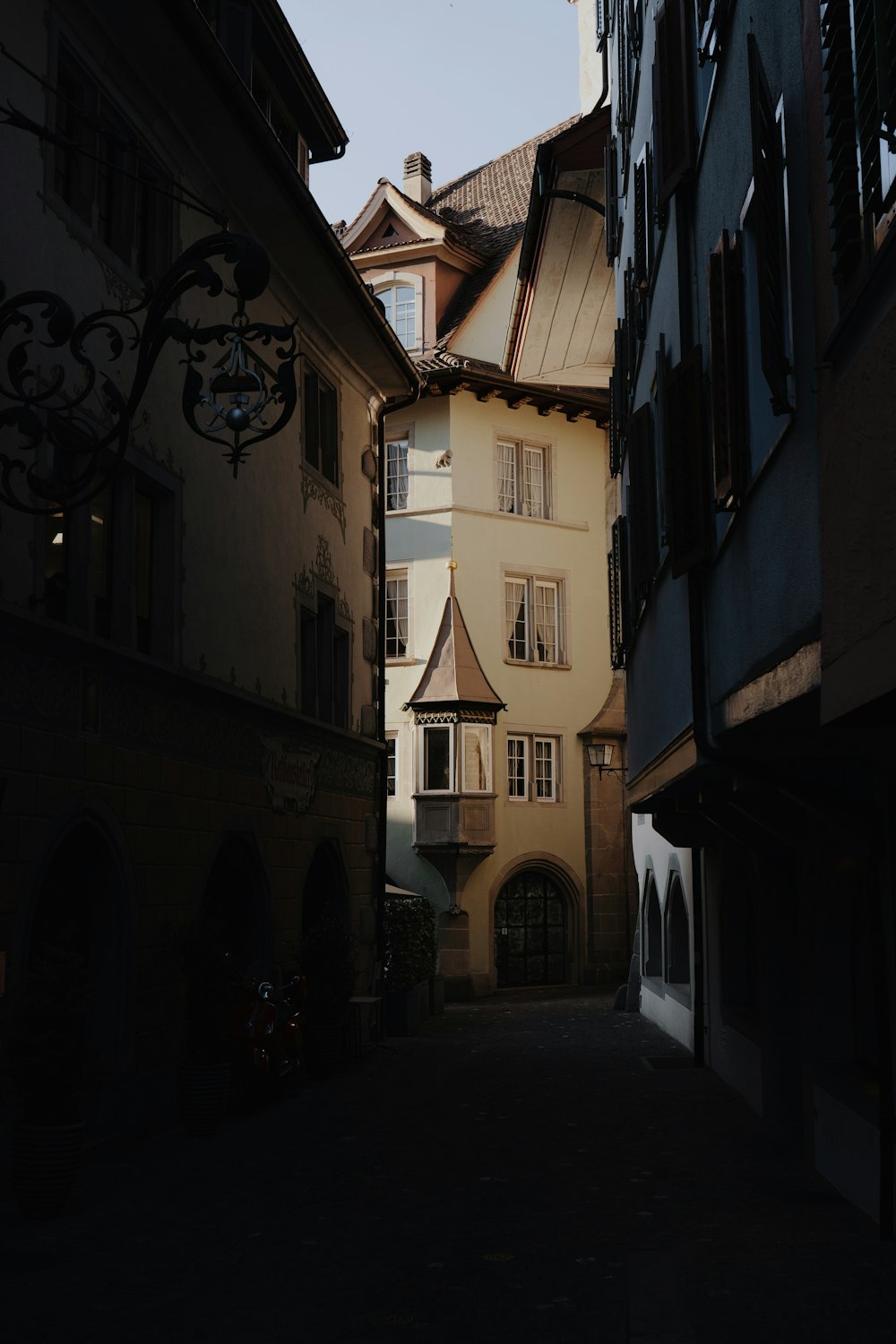 a narrow alley way with a clock tower in the distance