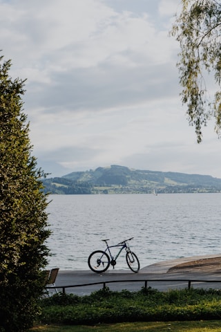 a bike is parked on a bench near the water