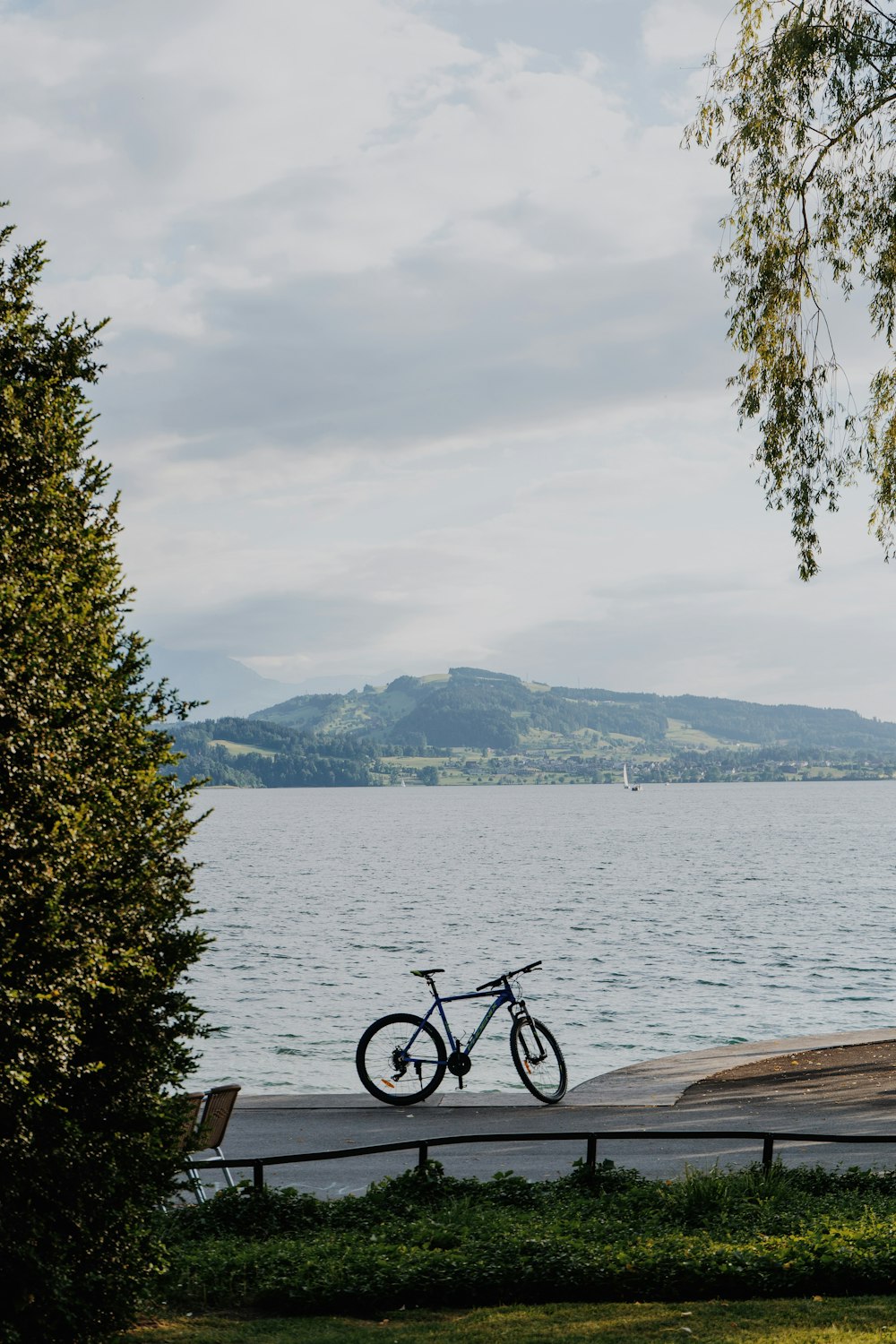 a bike is parked on a bench near the water