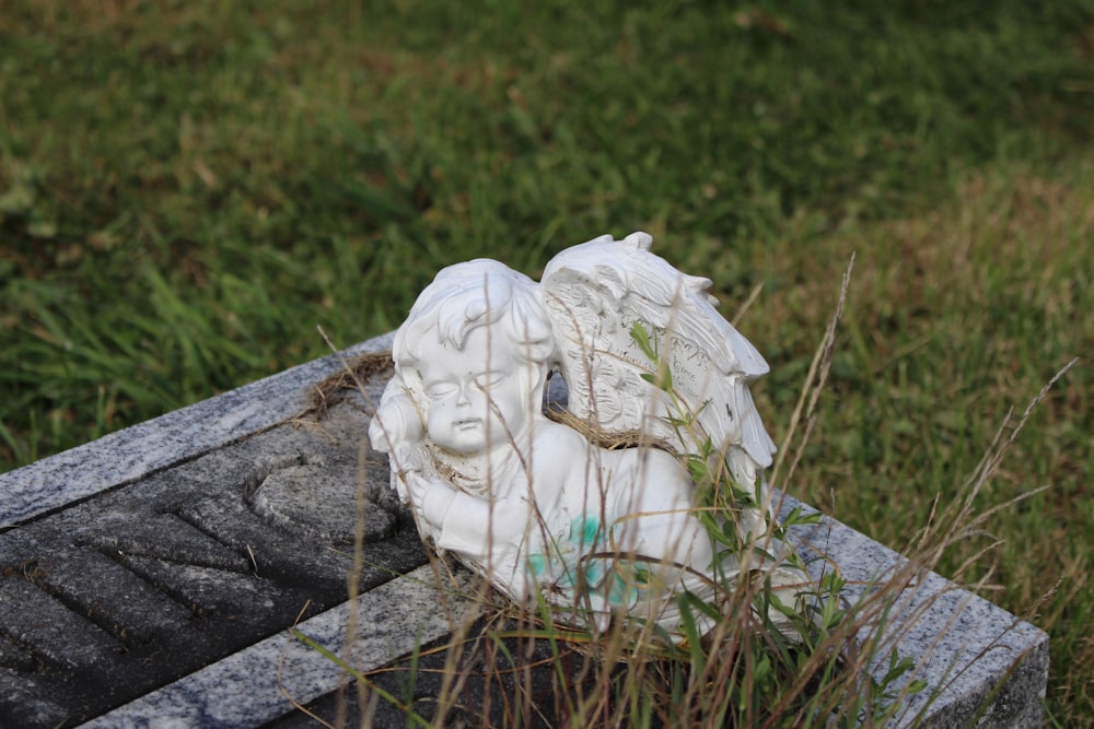 a statue of two heads in the grass