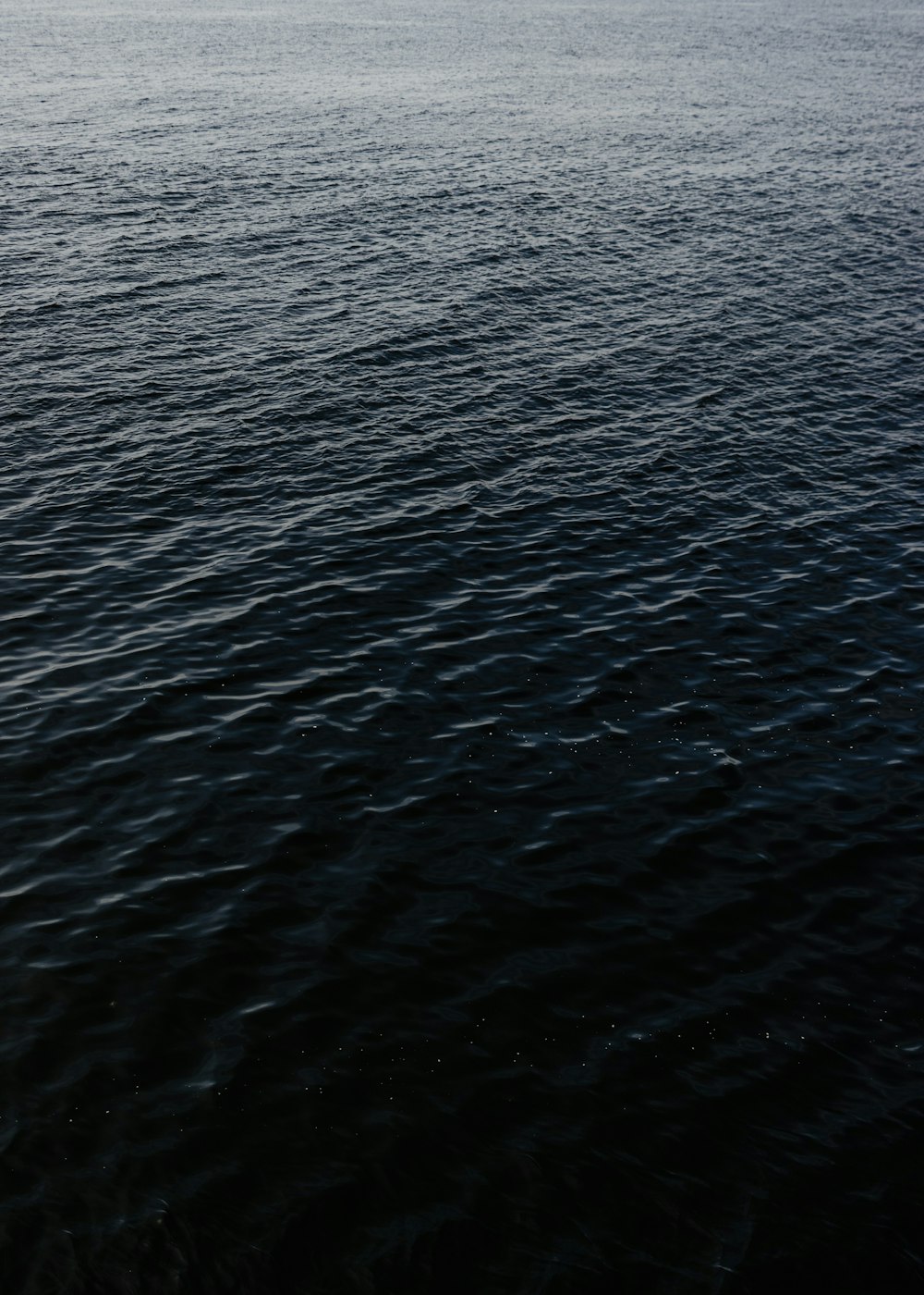 a large body of water with a boat in the distance