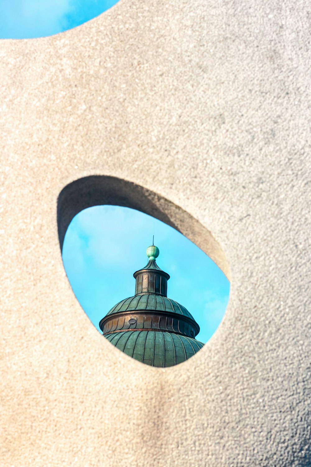 a view of a building through a hole in a wall