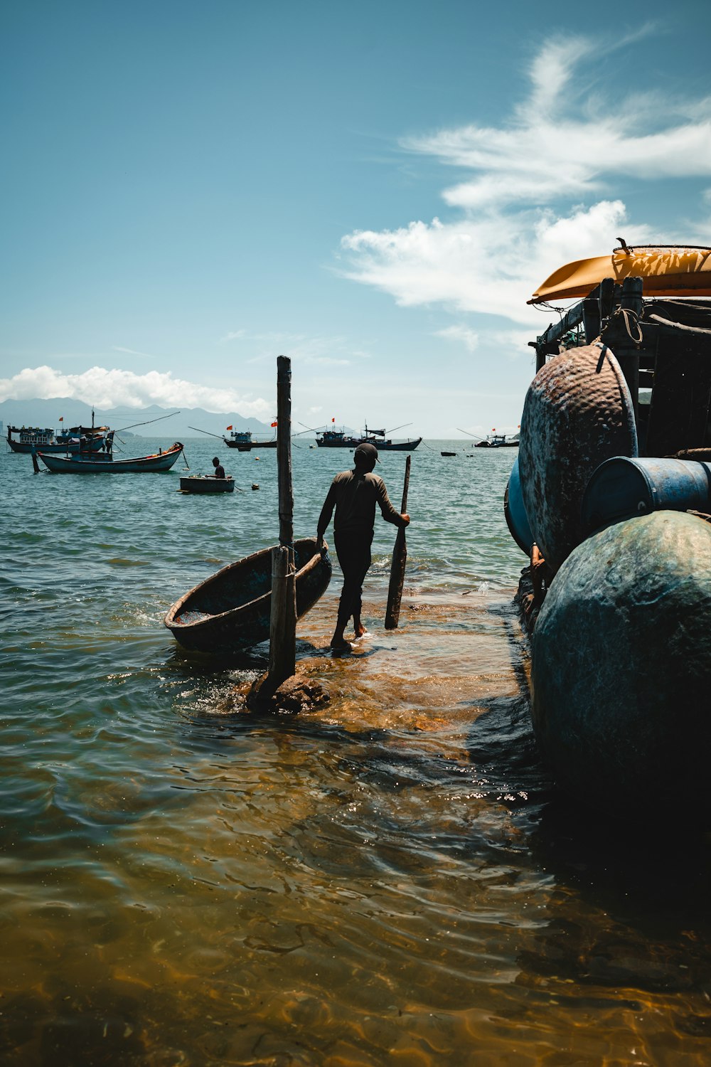 a man standing in the water next to a boat