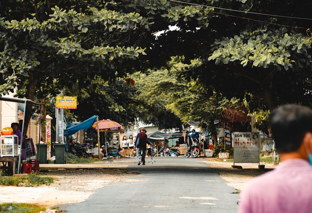 a man riding a bike down a street next to a forest