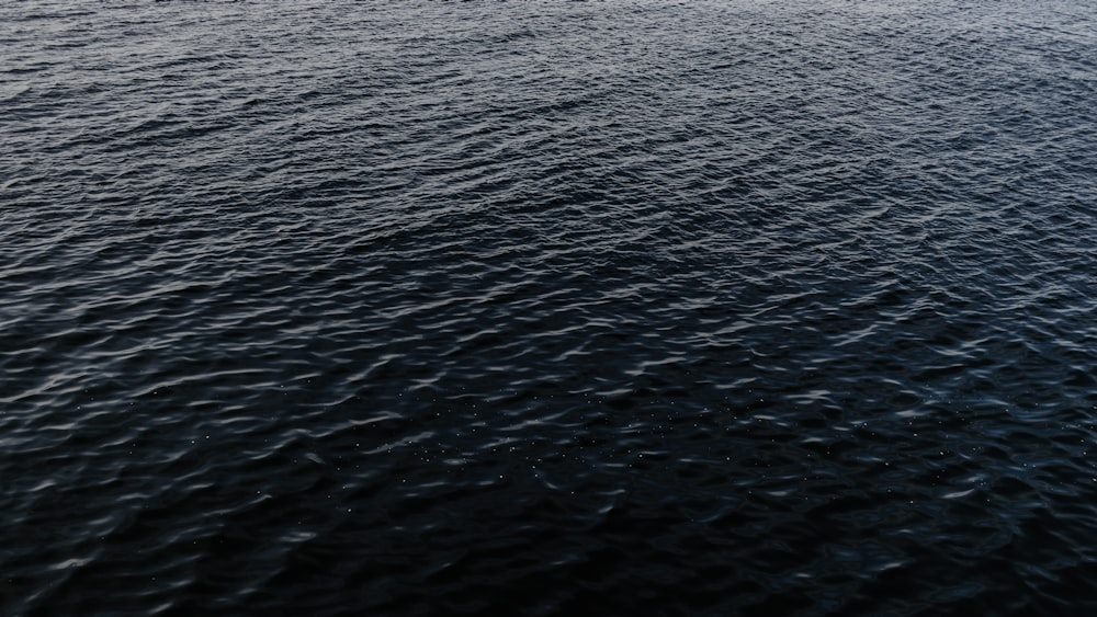 a large body of water with a boat in the distance