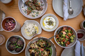a wooden table topped with bowls of food