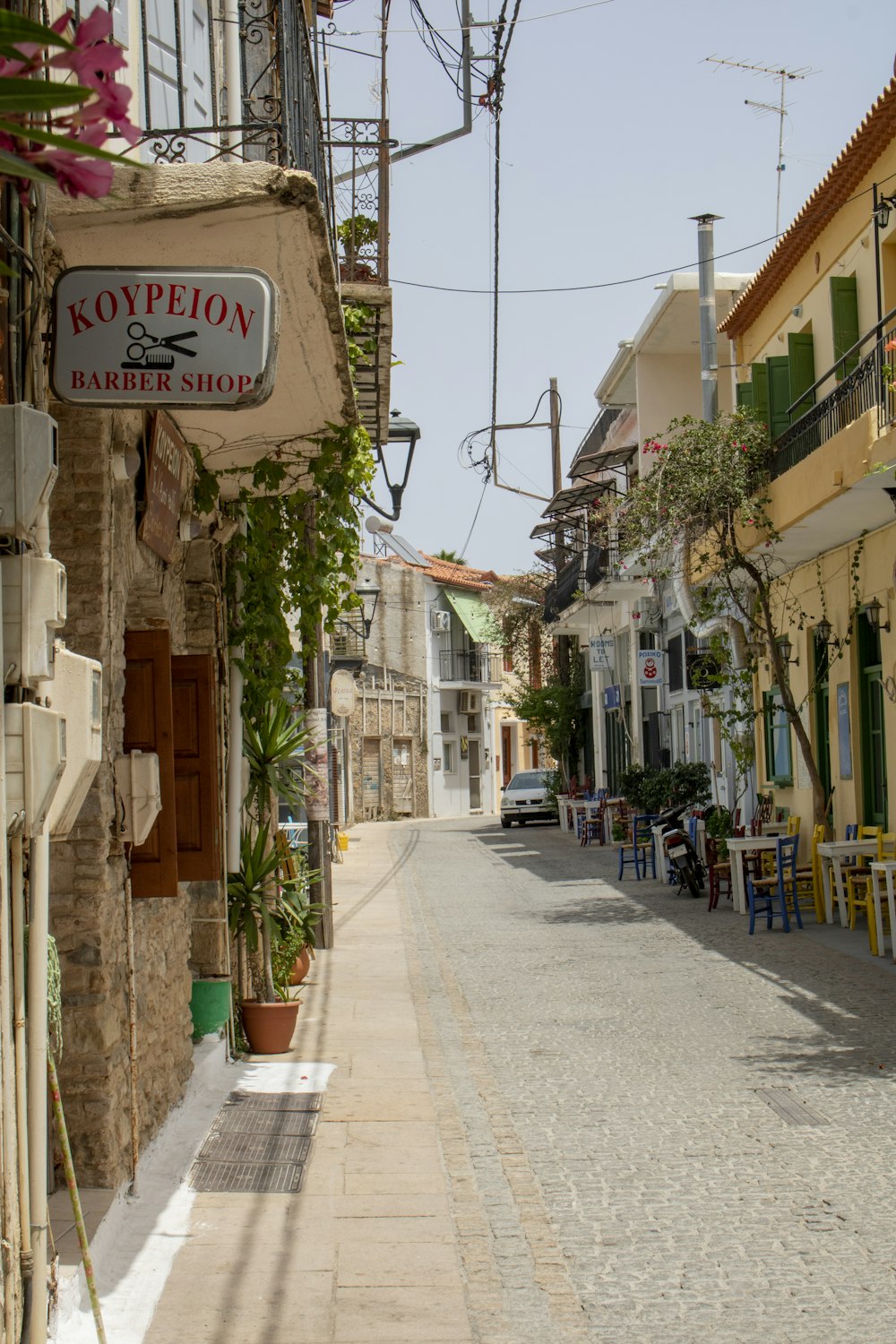 a cobblestone street lined with tables and chairs