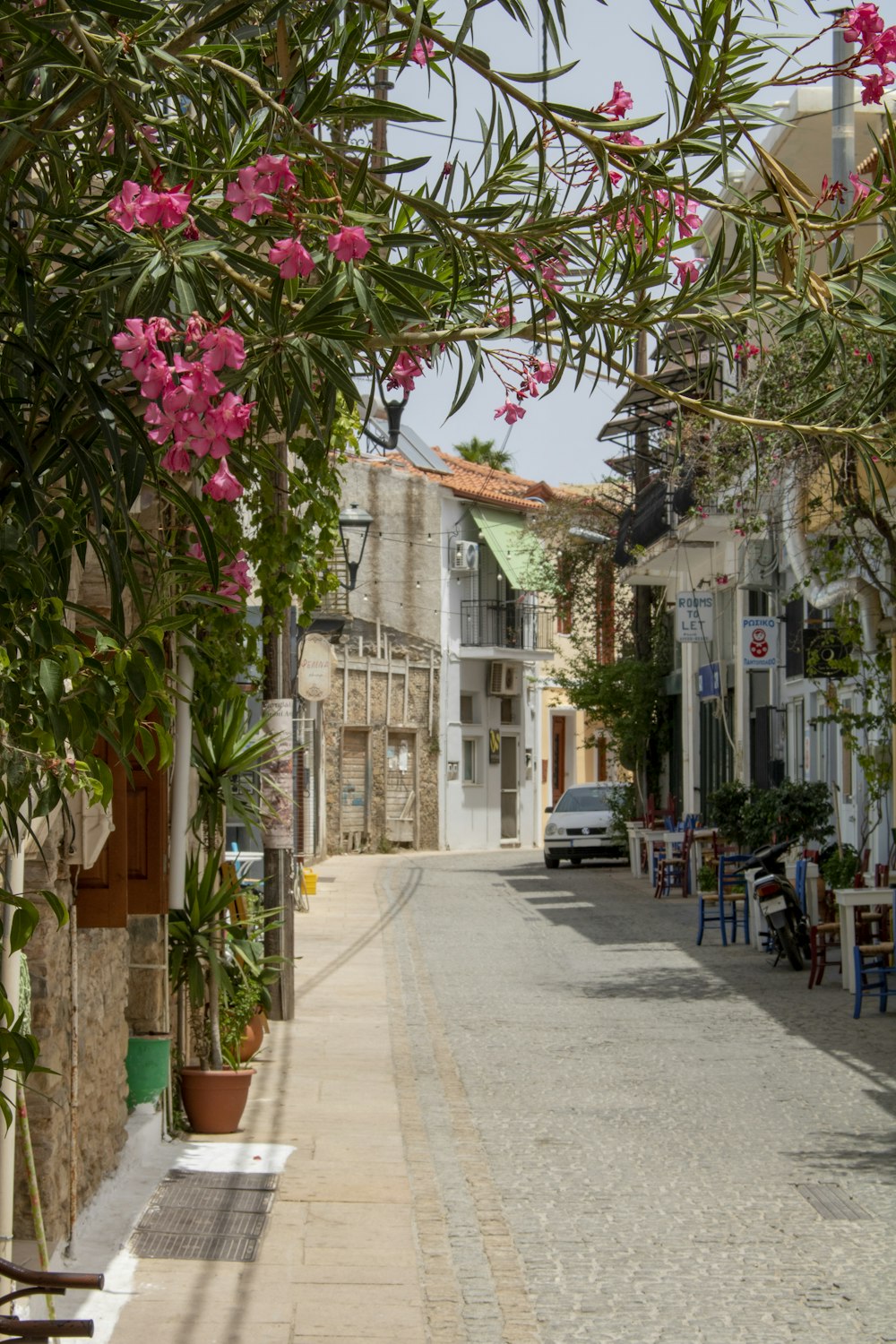 a street lined with tables and chairs next to tall buildings