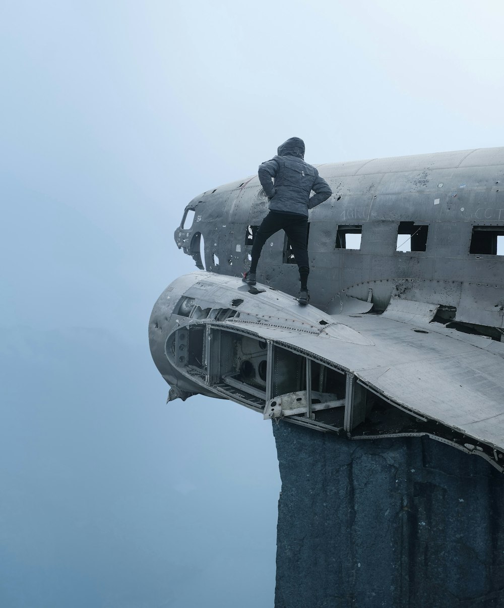 a man standing on the side of an airplane