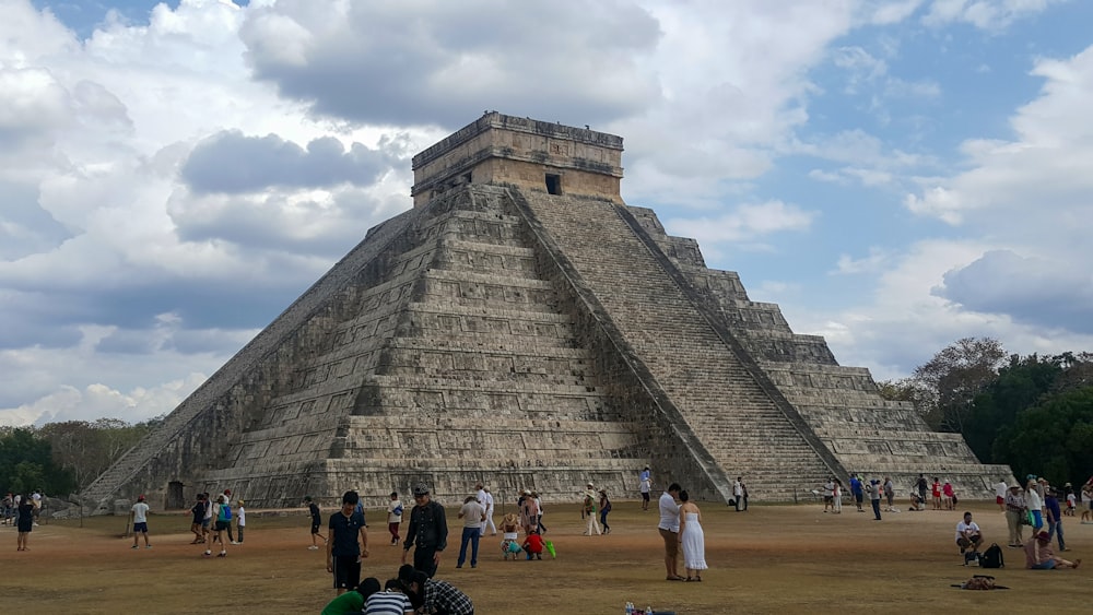 a group of people standing in front of a pyramid