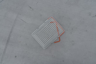 a metal object laying on the ground with orange lines