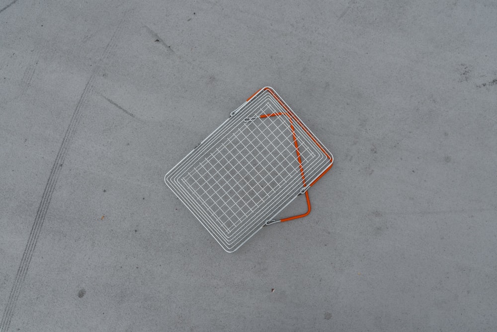 a metal object laying on the ground with orange lines