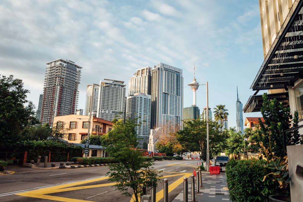 a city street with tall buildings in the background