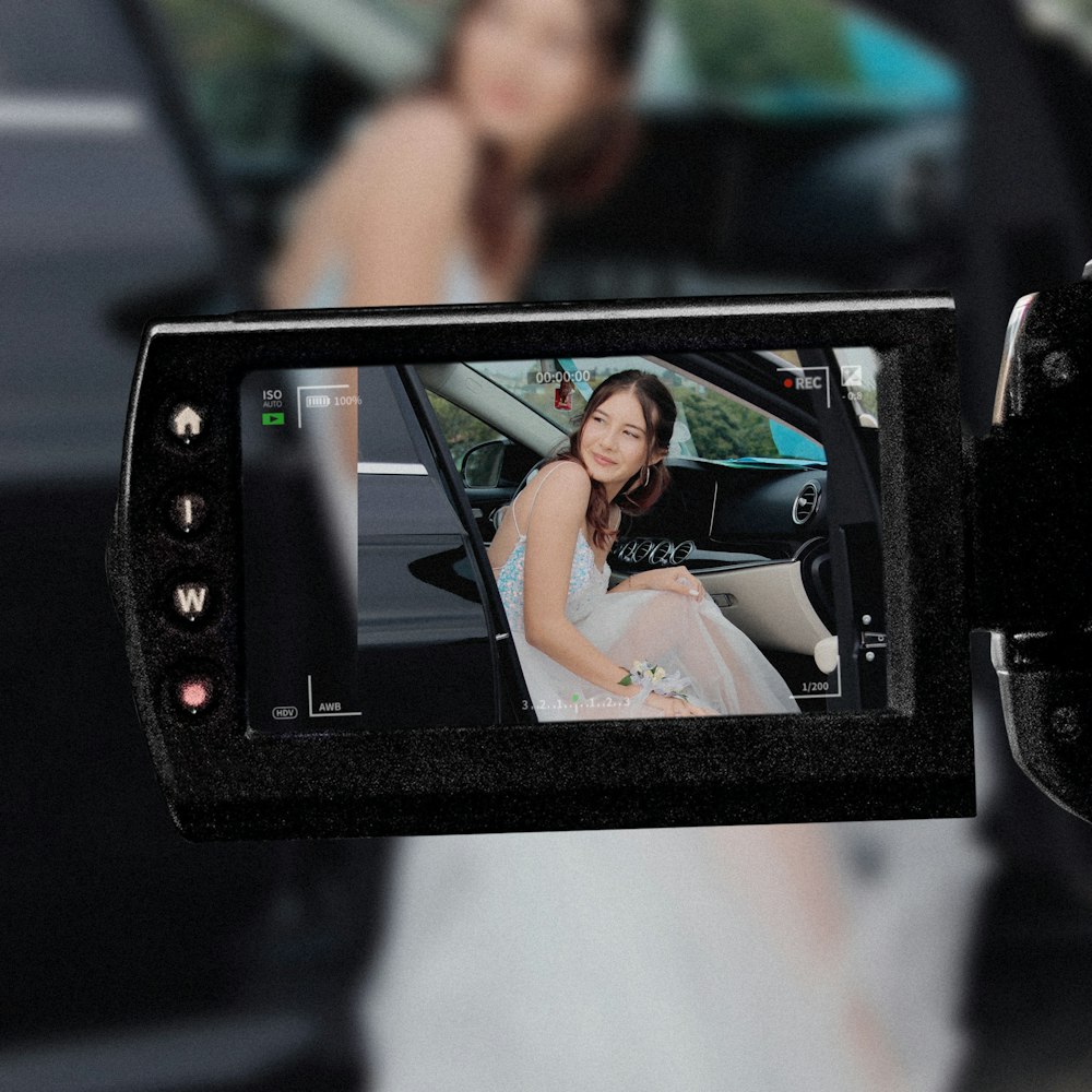 a person taking a picture of a woman in a wedding dress