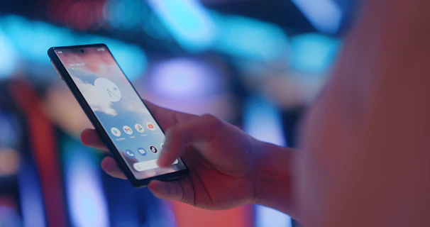 a person holding a cell phone in their hand