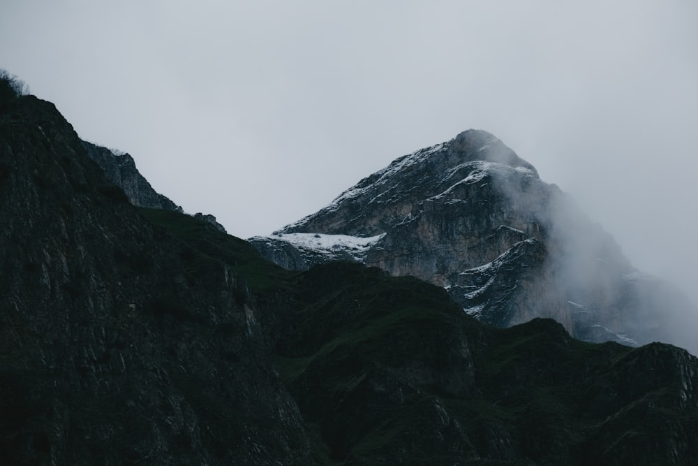 a tall mountain covered in snow and clouds