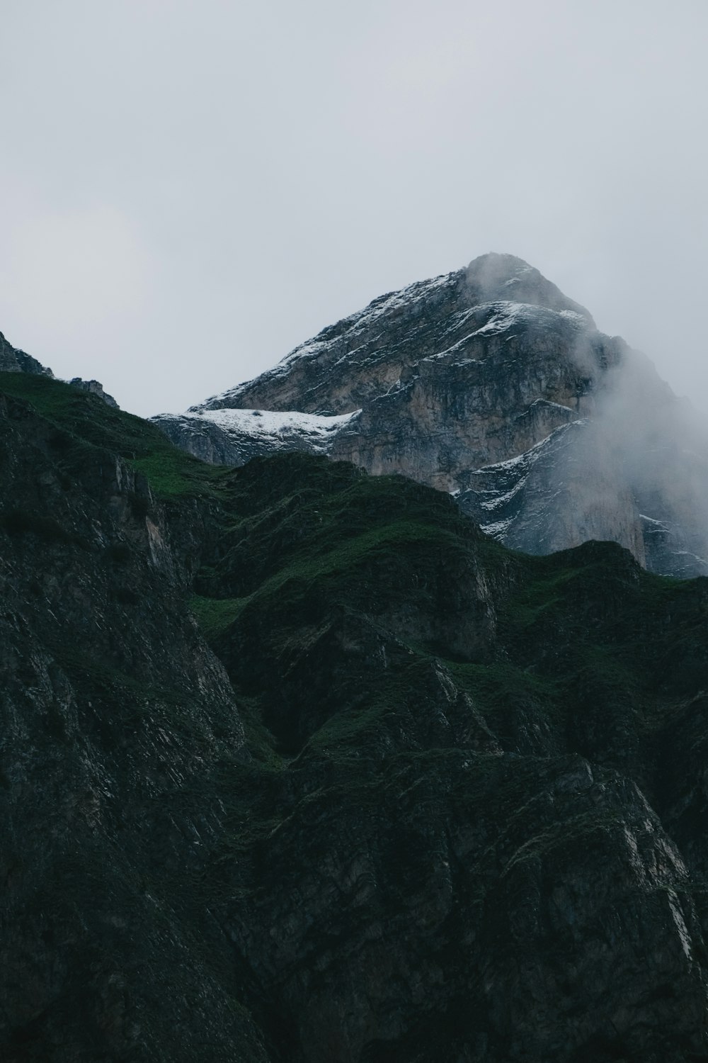 a very tall mountain covered in snow and clouds