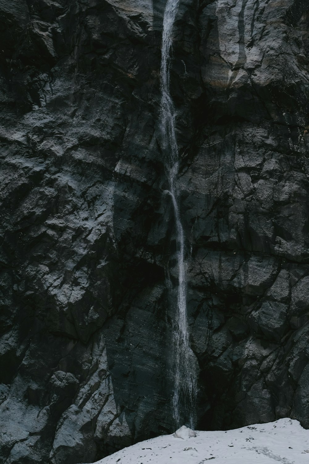 a man standing in front of a waterfall