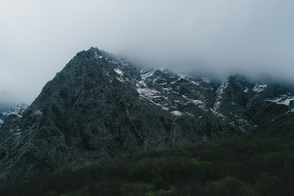 Una montagna molto alta coperta di neve in una giornata nuvolosa