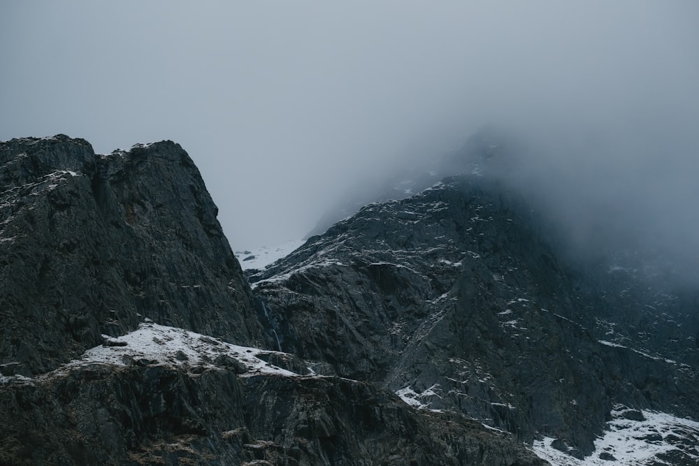 a very tall mountain covered in snow and clouds